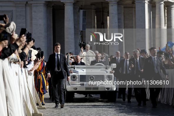 Pope Francis is waving as he is arriving to lead the weekly general audience in Saint Peter's Square, Vatican City, on June 5, 2024. 