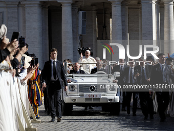 Pope Francis is waving as he is arriving to lead the weekly general audience in Saint Peter's Square, Vatican City, on June 5, 2024. (