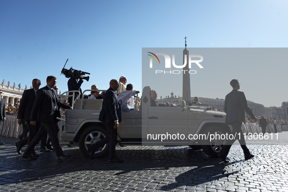 Pope Francis is waving as he is arriving to lead the weekly general audience in Saint Peter's Square, Vatican City, on June 5, 2024. 