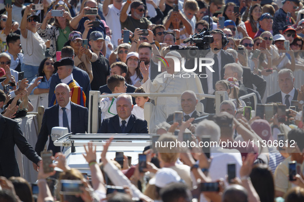 Pope Francis is waving as he is arriving to lead the weekly general audience in Saint Peter's Square, Vatican City, on June 5, 2024. 