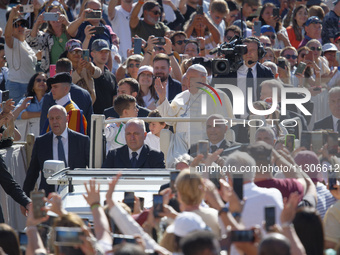 Pope Francis is waving as he is arriving to lead the weekly general audience in Saint Peter's Square, Vatican City, on June 5, 2024. (