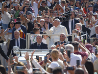 Pope Francis is waving as he is arriving to lead the weekly general audience in Saint Peter's Square, Vatican City, on June 5, 2024. (