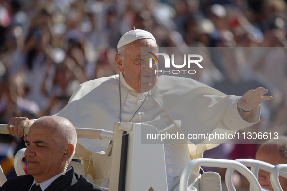 Pope Francis is waving as he is arriving to lead the weekly general audience in Saint Peter's Square, Vatican City, on June 5, 2024. 