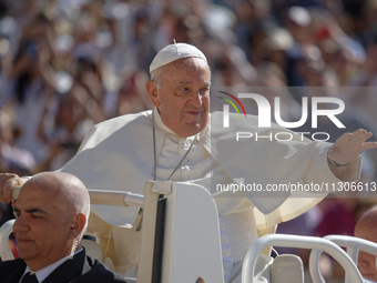 Pope Francis is waving as he is arriving to lead the weekly general audience in Saint Peter's Square, Vatican City, on June 5, 2024. (