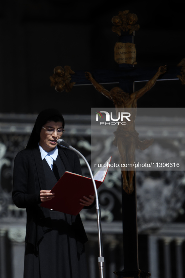 A nun is reading the words of the gospel in front of the crucifix during Pope Francis's weekly general audience in Saint Peter's Square, Vat...