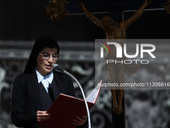 A nun is reading the words of the gospel in front of the crucifix during Pope Francis's weekly general audience in Saint Peter's Square, Vat...