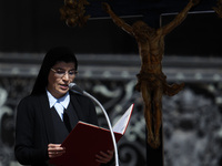 A nun is reading the words of the gospel in front of the crucifix during Pope Francis's weekly general audience in Saint Peter's Square, Vat...