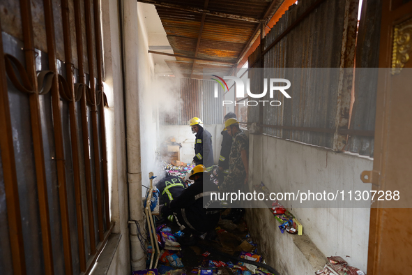 Nepali firefighters from the Armed Police Force, Nepal Army, and the Fire Brigade are dousing a fire that broke out in a warehouse in Kathma...