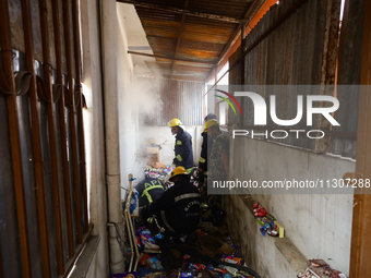 Nepali firefighters from the Armed Police Force, Nepal Army, and the Fire Brigade are dousing a fire that broke out in a warehouse in Kathma...