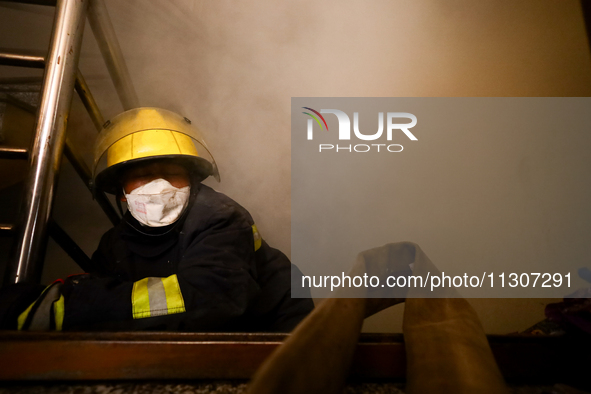 Nepali firefighters from the Armed Police Force, Nepal Army, and the Fire Brigade are dousing a fire that broke out in a warehouse in Kathma...