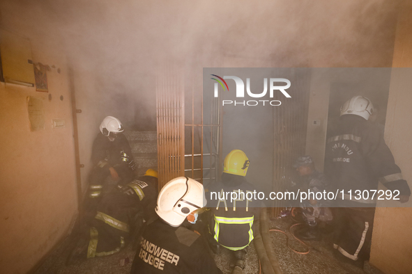 Nepali firefighters from the Armed Police Force, Nepal Army, and the Fire Brigade are dousing a fire that broke out in a warehouse in Kathma...