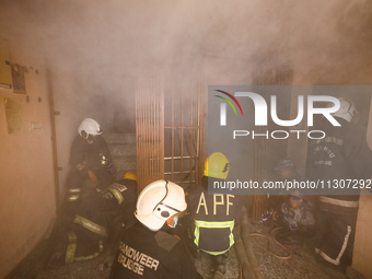 Nepali firefighters from the Armed Police Force, Nepal Army, and the Fire Brigade are dousing a fire that broke out in a warehouse in Kathma...