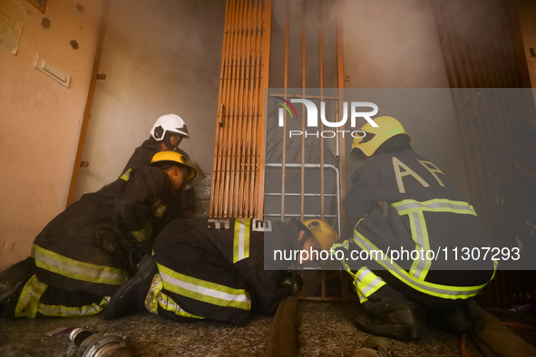 Nepali firefighters from the Armed Police Force, Nepal Army, and the Fire Brigade are dousing a fire that broke out in a warehouse in Kathma...