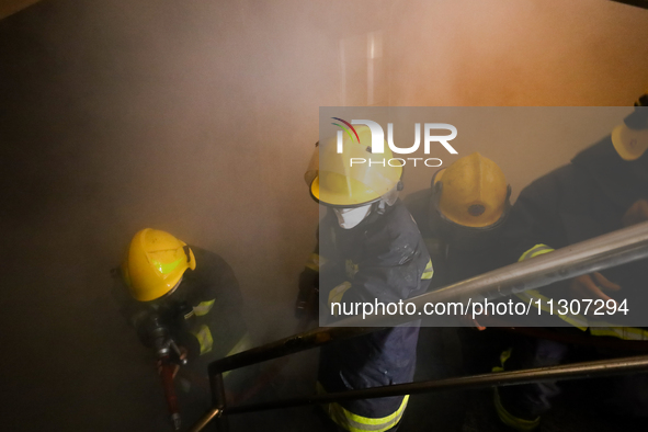 Nepali firefighters from the Armed Police Force, Nepal Army, and the Fire Brigade are dousing a fire that broke out in a warehouse in Kathma...