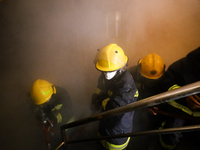 Nepali firefighters from the Armed Police Force, Nepal Army, and the Fire Brigade are dousing a fire that broke out in a warehouse in Kathma...