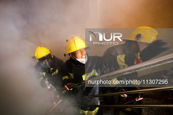 Nepali firefighters from the Armed Police Force, Nepal Army, and the Fire Brigade are dousing a fire that broke out in a warehouse in Kathma...