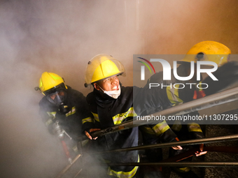 Nepali firefighters from the Armed Police Force, Nepal Army, and the Fire Brigade are dousing a fire that broke out in a warehouse in Kathma...