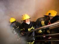 Nepali firefighters from the Armed Police Force, Nepal Army, and the Fire Brigade are dousing a fire that broke out in a warehouse in Kathma...