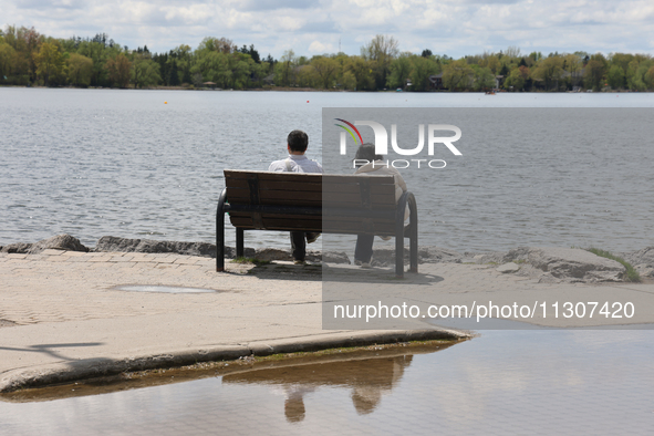 A couple is sitting by Lake Wilcox in Richmond Hill, Ontario, Canada, on May 12, 2024. 