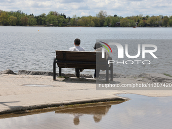 A couple is sitting by Lake Wilcox in Richmond Hill, Ontario, Canada, on May 12, 2024. (