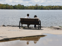 A couple is sitting by Lake Wilcox in Richmond Hill, Ontario, Canada, on May 12, 2024. (