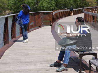 A man is playing a rhythmic tune on a musical instrument along a boardwalk by Lake Wilcox in Richmond Hill, Ontario, Canada, on May 12, 2024...