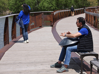 A man is playing a rhythmic tune on a musical instrument along a boardwalk by Lake Wilcox in Richmond Hill, Ontario, Canada, on May 12, 2024...