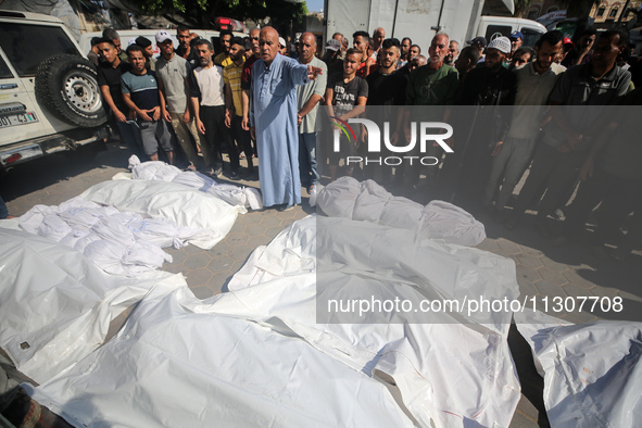 Palestinians are praying over the bodies of people killed in Israeli bombardment of a house in al-Maghazi refugee camp, at the Al-Aqsa Marty...