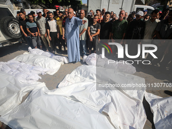 Palestinians are praying over the bodies of people killed in Israeli bombardment of a house in al-Maghazi refugee camp, at the Al-Aqsa Marty...