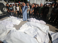 Palestinians are praying over the bodies of people killed in Israeli bombardment of a house in al-Maghazi refugee camp, at the Al-Aqsa Marty...