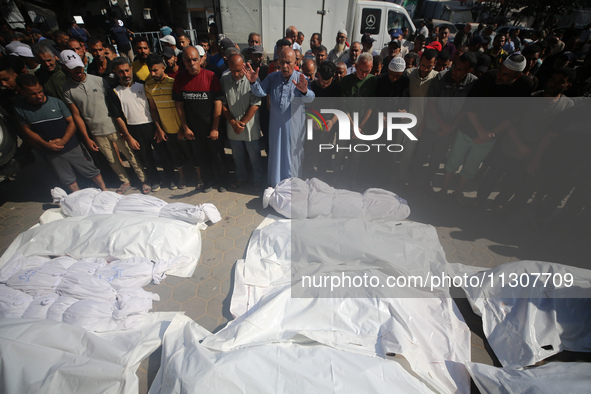 Palestinians are praying over the bodies of people killed in Israeli bombardment of a house in al-Maghazi refugee camp, at the Al-Aqsa Marty...