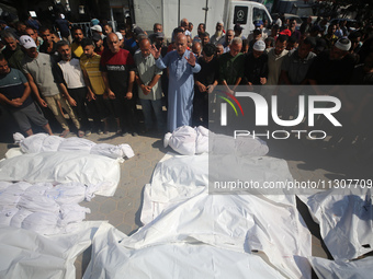 Palestinians are praying over the bodies of people killed in Israeli bombardment of a house in al-Maghazi refugee camp, at the Al-Aqsa Marty...