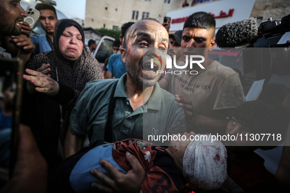 (EDITOR'S NOTE: Image depicts death) A Palestinian man is carrying the body of a young relative, killed in Israeli bombardment of a house in...