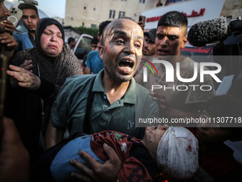 (EDITOR'S NOTE: Image depicts death) A Palestinian man is carrying the body of a young relative, killed in Israeli bombardment of a house in...