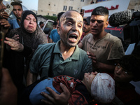 (EDITOR'S NOTE: Image depicts death) A Palestinian man is carrying the body of a young relative, killed in Israeli bombardment of a house in...