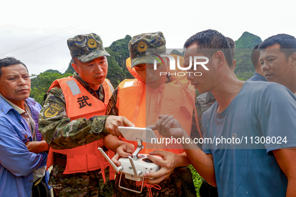 Armed police officers are using drones to conduct reconnaissance in Shilong Village, Gongchuan Township, Dahua County, Hechi city, South Chi...