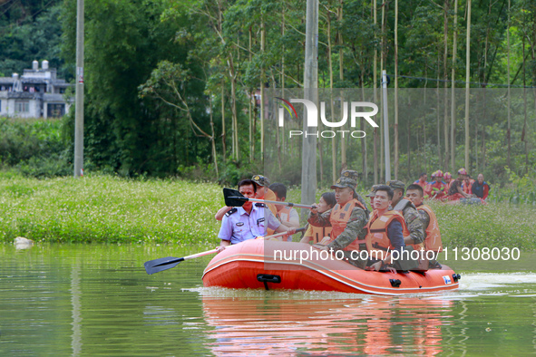 Armed police officers and soldiers are using rubber boats to move victims in Shilong Village, Gongchuan Township, Dahua County, Hechi city,...