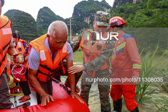 Armed police officers are moving victims of a disaster in Shilong Village, Gongchuan Township, Dahua County, Hechi city, South China's Guang...