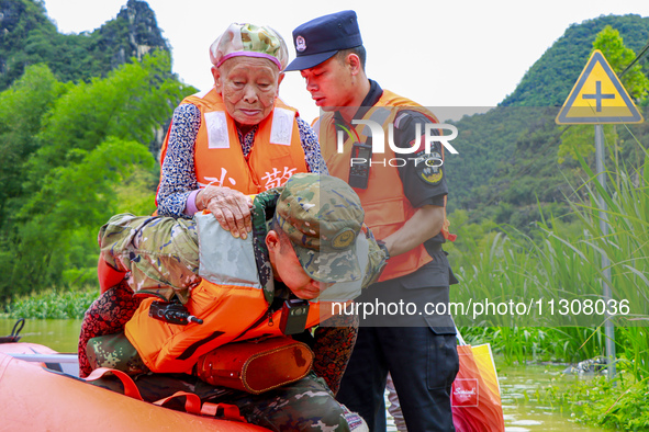 Armed police officers are moving victims of a disaster in Shilong Village, Gongchuan Township, Dahua County, Hechi city, South China's Guang...