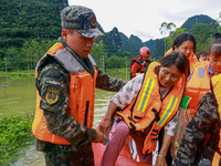 Armed police officers are moving victims of a disaster in Shilong Village, Gongchuan Township, Dahua County, Hechi city, South China's Guang...