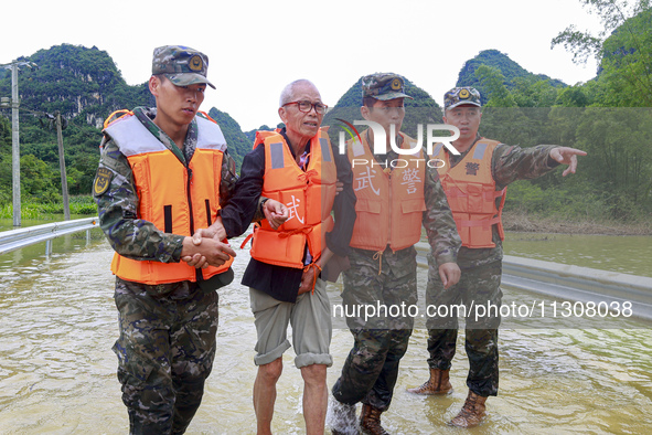 Armed police officers are moving victims of a disaster in Shilong Village, Gongchuan Township, Dahua County, Hechi city, South China's Guang...