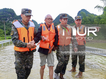 Armed police officers are moving victims of a disaster in Shilong Village, Gongchuan Township, Dahua County, Hechi city, South China's Guang...