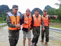 Armed police officers are moving victims of a disaster in Shilong Village, Gongchuan Township, Dahua County, Hechi city, South China's Guang...