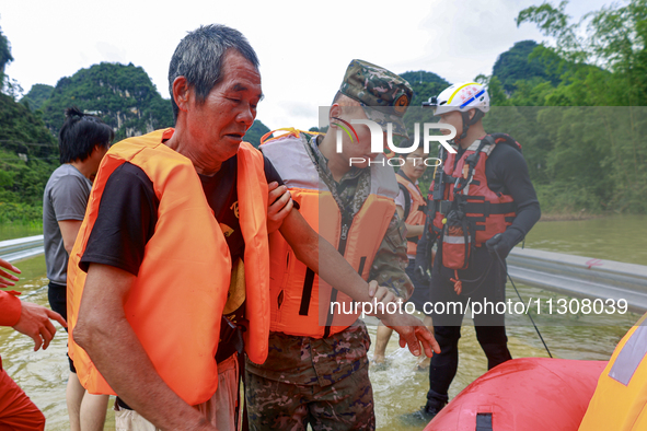 Armed police officers are moving victims of a disaster in Shilong Village, Gongchuan Township, Dahua County, Hechi city, South China's Guang...