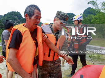 Armed police officers are moving victims of a disaster in Shilong Village, Gongchuan Township, Dahua County, Hechi city, South China's Guang...