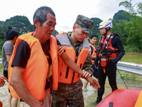 Armed police officers are moving victims of a disaster in Shilong Village, Gongchuan Township, Dahua County, Hechi city, South China's Guang...