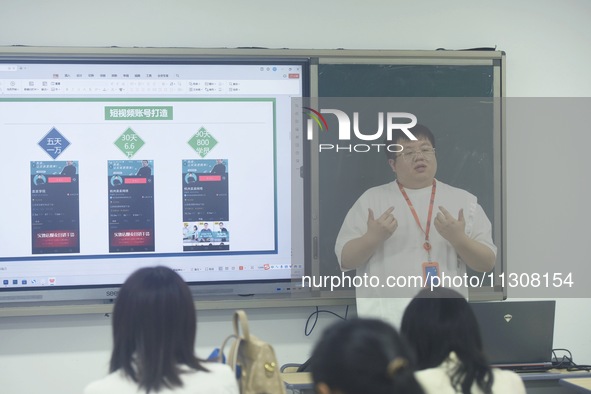 A teacher is teaching students how to make short videos in a classroom in Hangzhou, China, on June 5, 2024. 