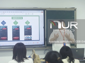 A teacher is teaching students how to make short videos in a classroom in Hangzhou, China, on June 5, 2024. (