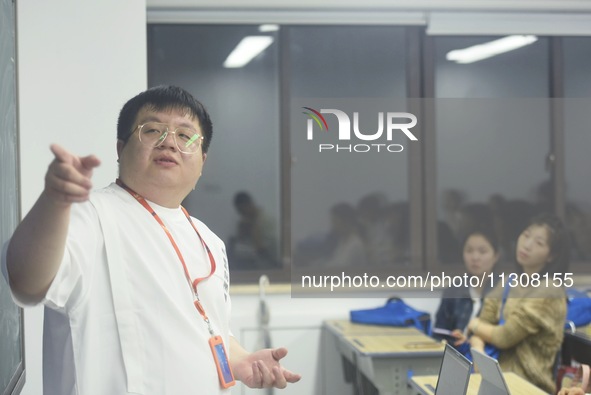 A teacher is teaching students how to make short videos in a classroom in Hangzhou, China, on June 5, 2024. 