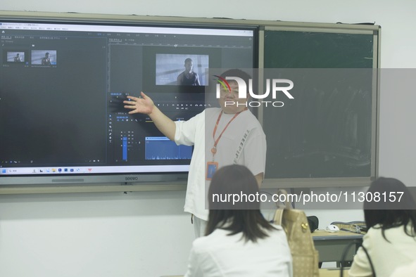 A teacher is teaching students how to make short videos in a classroom in Hangzhou, China, on June 5, 2024. 